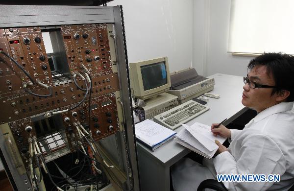 A staff member analyses the collected objects to check the radiation level at an environment supervision station in Shanghai, east China, March 15, 2011. 