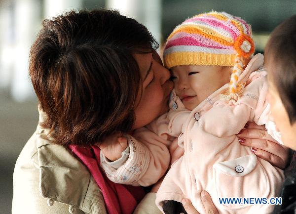 A mother evacuated from quake-hit Japan kisses her baby she hasn't seen for days at the Dalian Zhoushuizi International Airport in Dalian, northeast China's Liaoning Province, March 16, 2011. 