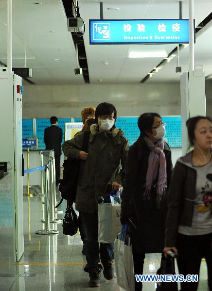 Chinese nationals evacuated from quake-hit Japan pass through the inspection and quarantine tunnel at the Dalian Zhoushuizi International Airport in Dalian, northeast China's Liaoning Province, March 16, 2011.