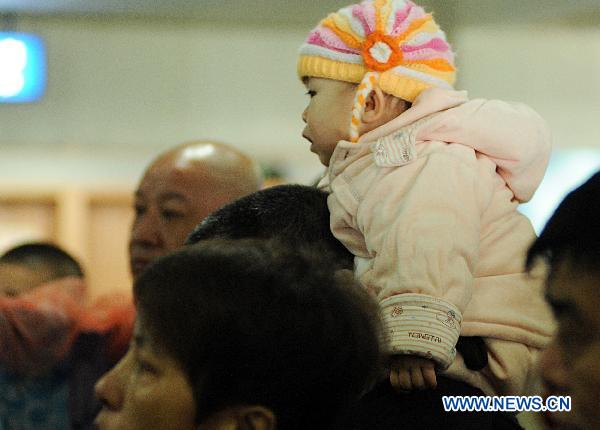 A baby waits for mother coming back from quake-hit Japan at the Dalian Zhoushuizi International Airport in Dalian, northeast China's Liaoning Province, March 16, 2011. 