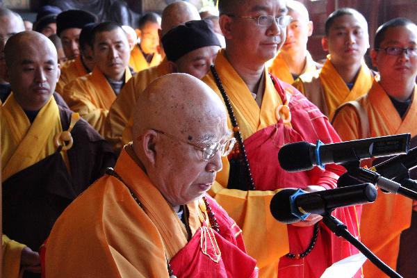 Master Chuanyin, president of Buddhist Association of China, speaks as others pray for the lost lives during the earthquake that took place in Japan last week in Beijing, capital of China, March 16, 2011. 