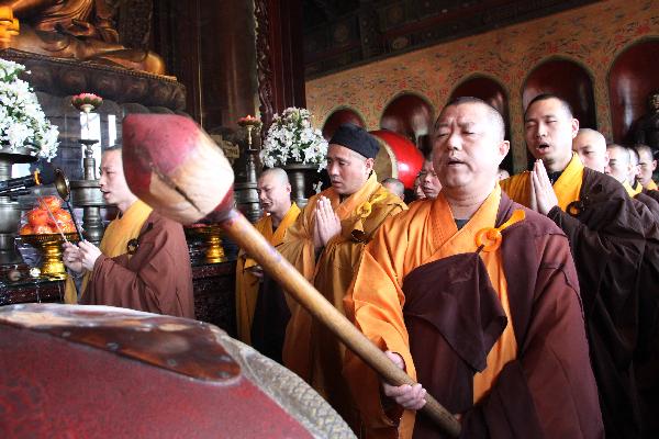 Members of Buddhist Association of China pray for the lost lives during the earthquake that took place in Japan last week in Beijing, capital of China, March 16, 2011.