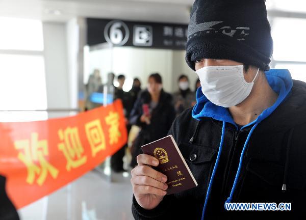 A Chinese passenger departed from Japan arrive at an airport in Qingdao, east China's Shandong Province, March 16, 2011. 