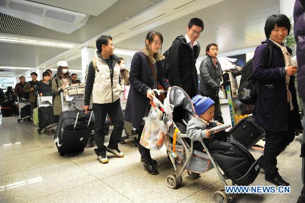 Chinese passengers departed from Japan arrive at an airport in Qingdao, east China's Shandong Province, March 16, 2011. 