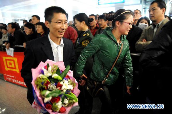 A Chinese passenger (L) departed from Japan arrives at an airport in Qingdao, east China's Shandong Province, March 16, 2011. 