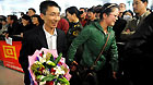 A Chinese passenger (L) departed from Japan arrives at an airport in Qingdao, east China's Shandong Province, March 16, 2011.