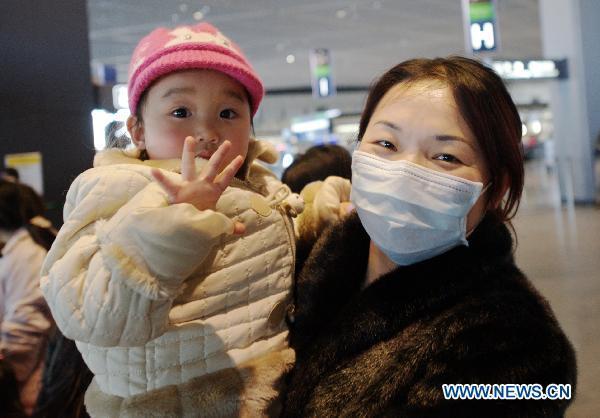 Chinese woman Zhang with her child poses for photos before leaving at the counter of Delta Air at Narita airoprt in Tokyo, Japan, March 17, 2011. 