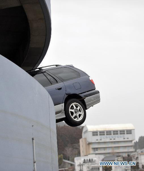 A car is seen stuck into the wall of a parking lot, the aftermath of the March 11 tsunami and earthquake, in the city of Kesennuma in Miyagi prefecture, Japan, on March 20, 2011. 
