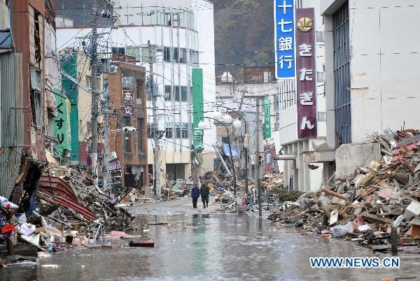 Two men stand among the debris from the March 11 tsunami and earthquake in the city of Kesennuma in Miyagi prefecture, Japan, on March 20, 2011. 