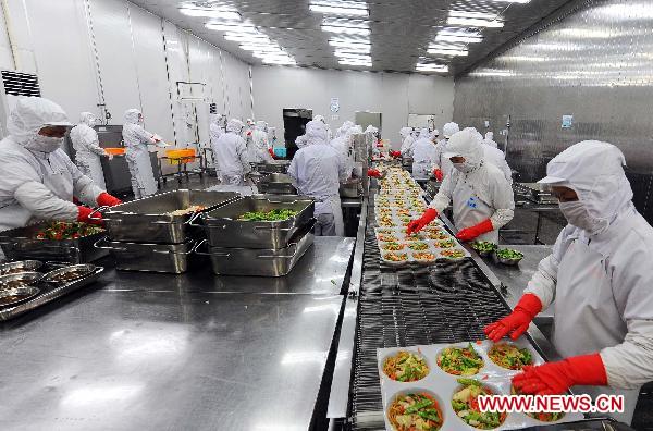Workers work on the production line at a food factory of Ajinomoto in Lianyungang City, east China's Jiangsu Province, March 18, 2011. 