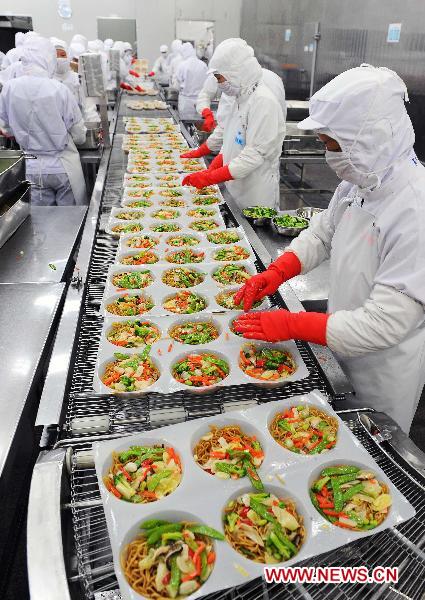 Workers work on the production line at a food factory of Ajinomoto in Lianyungang City, east China's Jiangsu Province, March 18, 2011. 