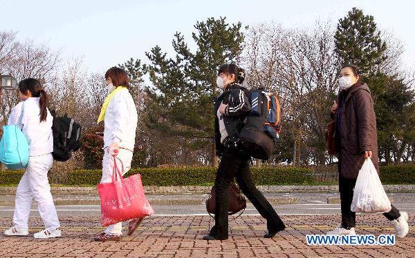 Chinese evacuees walk to a bus heading for airport before flying back to China in Niigata, Japan, March 20, 2011. 