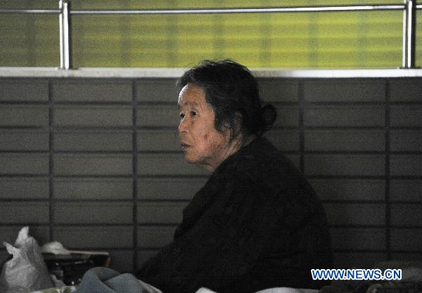 A Japanese woman sits inside a sports park used as a makeshift shelter in Fukushima, Japan, March 19, 2011.