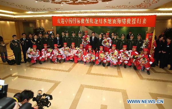 Crew members of the Chinese International Search and Rescue Team (CISAR) pose for group photos during a welcome-home ceremony at the Capital Airport in Beijing, capital of China, March 21, 2011. 