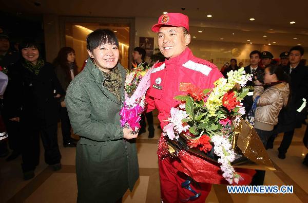 Zhang Hongxia (L, Front) greets her husband Li Qingkai (R, Front), who is a member of the Chinese International Search and Rescue Team (CISAR) at the Capital Airport in Beijing, capital of China, March 21, 2011. 