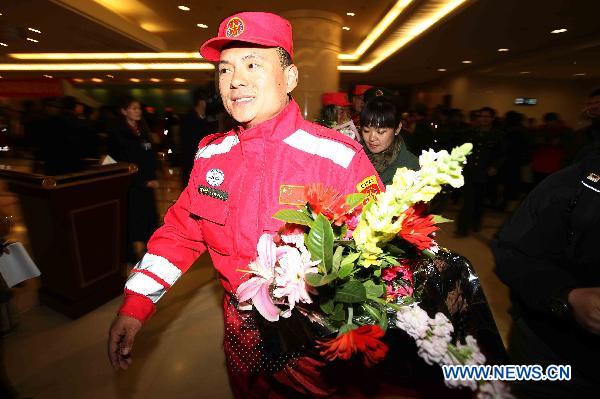 Li Qingkai (Front), who is a member of the Chinese International Search and Rescue Team (CISAR), walks out of the Capital Airport in Beijing, capital of China, March 21, 2011. 