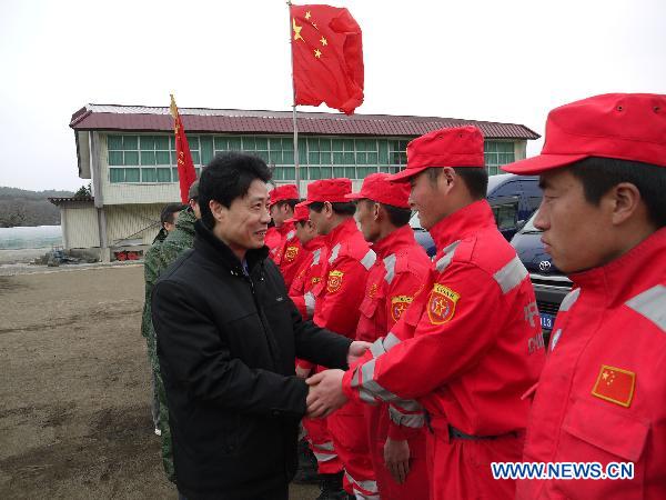 Hu Shengcai (L), consul general of the Chinese consulate general in Sapporo, shakes hands with members of Chinese rescue members during a farewell ceremony in Ofunato, Iwate Prefecture, Japan, March 20, 2011.