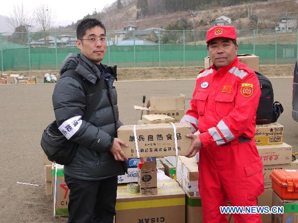 Yin Guanghui (R), head of Chinese rescue team, donates relief goods to a Japanese during a farewell ceremony in Ofunato, Iwate Prefecture, Japan, March 20, 2011.