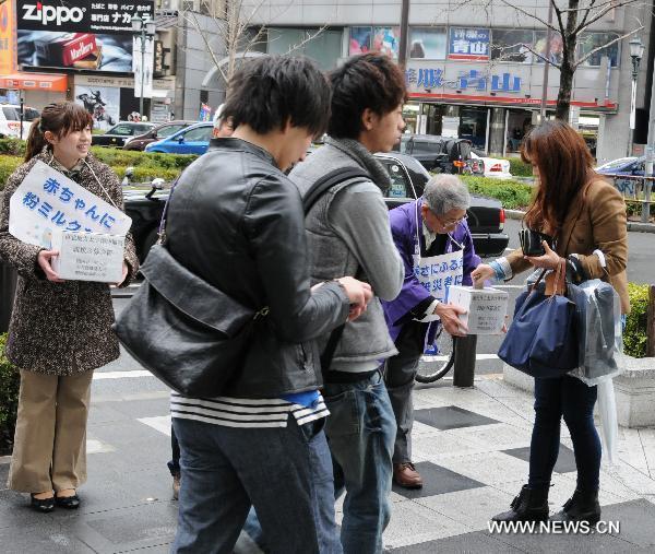 Residents who live in Osaka raise money for earthquake-stricken area on a street in Osaka, Japan, March 21, 2011. 