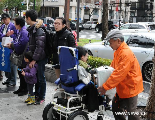 Residents who live in Osaka raise money for earthquake-stricken area on a street in Osaka, Japan, March 21, 2011. 