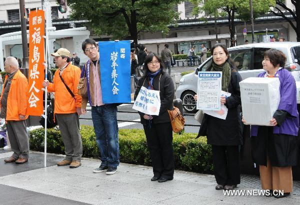 Residents who live in Osaka raise money for earthquake-stricken area on a street in Osaka, Japan, March 21, 2011. 