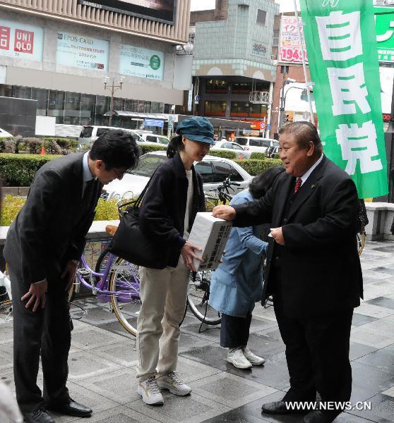 Residents who live in Osaka raise money for earthquake-stricken area on a street in Osaka, Japan, March 21, 2011.