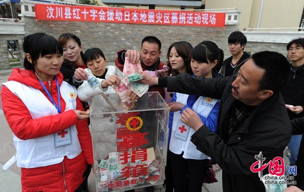 Locals donate money at a fund raising event for victims of the Japanese earthquake and tsunami in Wenchuan County, Sichuan Province, held by the Red Cross on March 20, 2011.