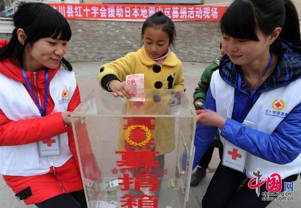 Locals donate money at a fund raising event for victims of the Japanese earthquake and tsunami in Wenchuan County, Sichuan Province, held by the Red Cross on March 20, 2011.