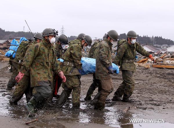 Self-Defence Forces members remove a body in kesennuma, Miyagi-ken in Japan, March 21, 2011. 