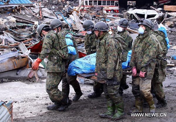 Self-Defence Forces members remove a body in kesennuma, Miyagi-ken in Japan, March 21, 2011. 