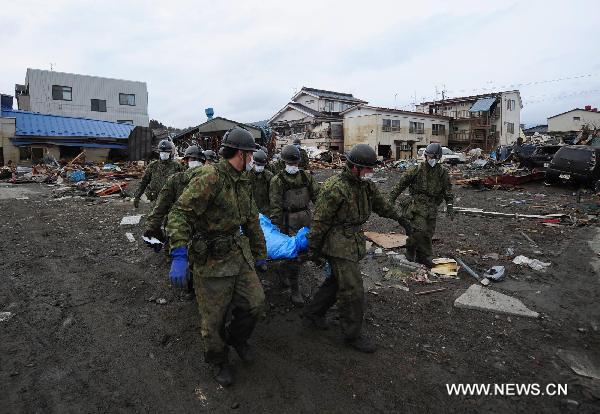 Self-Defence Forces members remove a body in kesennuma, Miyagi-ken in Japan, March 21, 2011. 