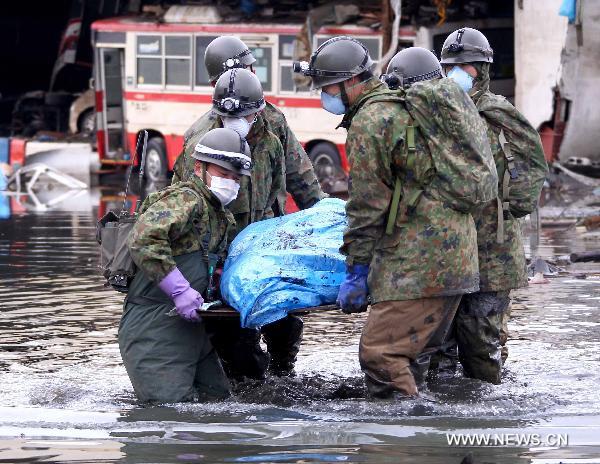 Self-Defence Forces members remove a body in kesennuma, Miyagi-ken in Japan, March 21, 2011. 