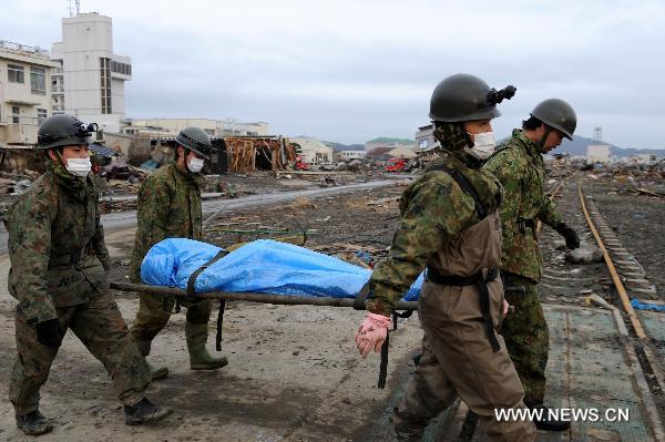 Self-Defence Forces members remove a body in kesennuma, Miyagi-ken in Japan, March 21, 2011. 