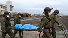 Self-Defence Forces members remove a body in kesennuma, Miyagi-ken in Japan, March 21, 2011.