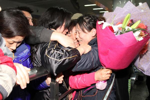 A trainee of China Dalian International Cooperation (Group) Holdings Ltd. is embraced as she arrives in Dalian, northeast China&apos;s Liaoning Province, March 19, 2011.