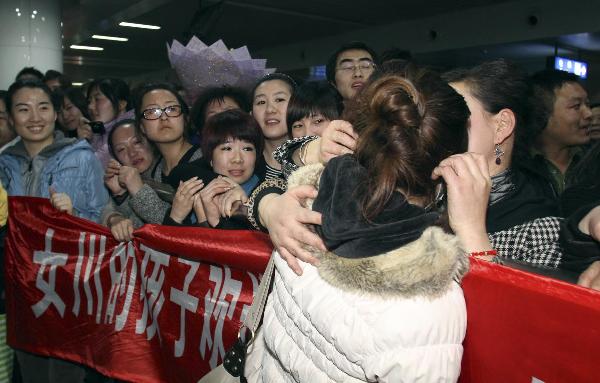 A trainee of China Dalian International Cooperation (Group) Holdings Ltd. is embraced as she arrives in Dalian, northeast China&apos;s Liaoning Province, March 19, 2011. 