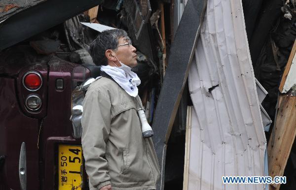 A man looks at his home among debris in quake-devastated Iwate Prefecture, Japan, on March 21, 2011.