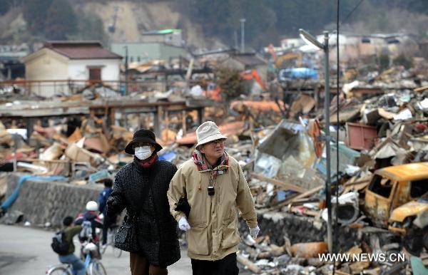 Local residents look at ruined houses in the quake-hit Oshikacho of Miyagi Prefecture, Japan, March 23, 2011. 