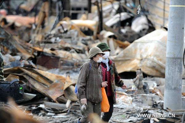 Local residents check their ruined houses in the quake-hit Oshikacho of Miyagi Prefecture, Japan, March 23, 2011.