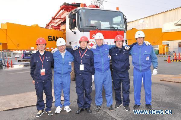 Engineers pose for photo in front of the Chinese-made pump truck in Chiba-ken, Japan, March 26, 2011. 