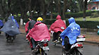 Citizens ride on a street on a rainy day in Haikou, capital of south China's Hainan Province, March 29, 2011.