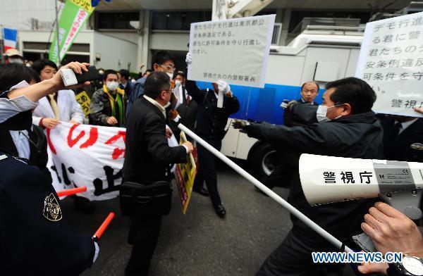 Protesters confront with policemen in front of the headquarters of Tokyo Electric Power Company, Inc. (TEPCO) during an anti-nuclear march in Tokyo, Japan, March 31, 2011.