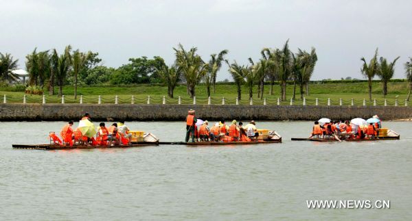 Photo taken on April 9, 2011 shows tourists on bamboo rafts drift down a river near the International Conference Center of the Bo'ao Forum for Asia (BFA) in Bo'ao Township, south China's Hainan Province. The 10th BFA would be held here from April 14 to 16 and the forum has largely promoted the local economy in the past 10 years. (Xinhua/Hou Jiansen) 