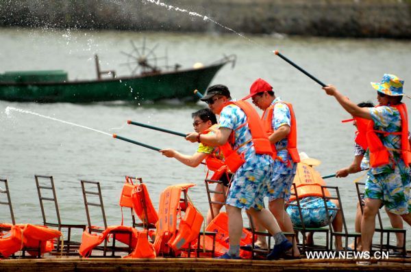 Photo taken on April 9, 2011 shows tourists on a bamboo raft play waterguns near the International Conference Center of the Bo'ao Forum for Asia (BFA) in Bo'ao Township, south China's Hainan Province. The 10th BFA would be held here from April 14 to 16 and the forum has largely promoted the local economy in the past 10 years. (Xinhua/Hou Jiansen) 