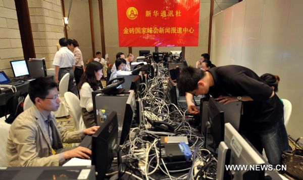 Journalists are seen at the working area of Xinhua News Agency in the media centre of the BRICS Leaders Meeting in Sanya, south China's Hainan Province, April 13, 2011.