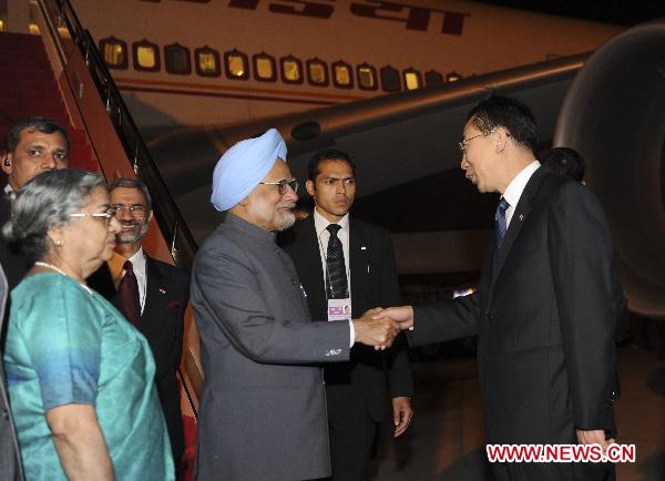 Indian Prime Minister Manmohan Singh (C front) is greeted at the airport in Sanya, south China's Hainan Province, April 12, 2011.