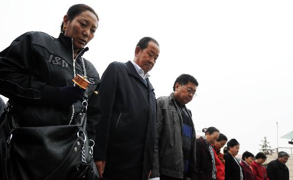 Local people mourn for the victims of the Yushu earthquake at a plaza in Xining, capital of northwest China's Qinghai Province, April 14, 2011. 