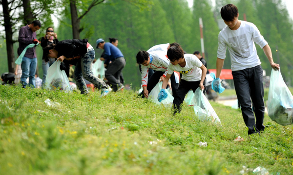 People pick up trash littered along Dongjing River Dike in Qianjiang City, central China's Hubei Province, April 18, 2011. The event was part of an environmental campaign launched to improve people's awareness about dropping litter. 