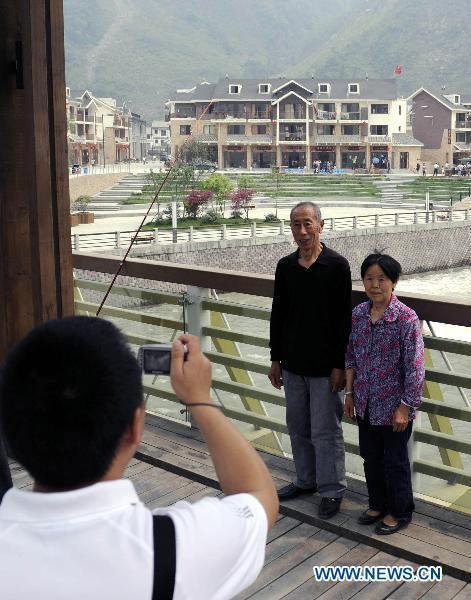 People take photos in the rebuilt Yingxiu Town of southwest China's Sichuan Province on April 30, 2011. 