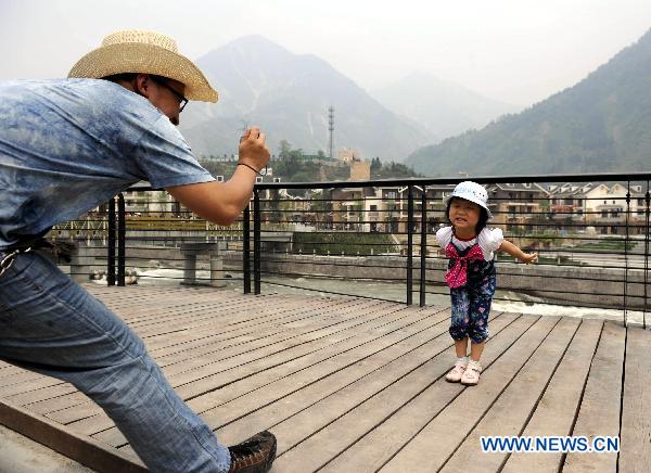 People take photos in the rebuilt Yingxiu Town of southwest China's Sichuan Province on April 30, 2011. 